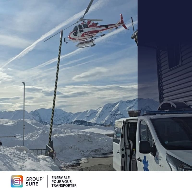 Hélicoptère en vol au-dessus de l’Alpe d’Huez, avec un véhicule sanitaire Group’Sure stationné près de la zone d’intervention.